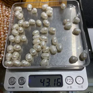 Perle d'acqua dolce barocche sfuse pesate su una bilancia digitale per gioielli fai da te