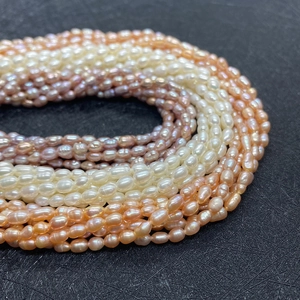 Gros plan de perles de riz naturelles en blanc rose et violet pour bijoux DIY