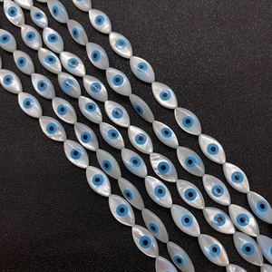Makroaufnahme von Marquise-Muschelperlen mit blauem Evil-Eye-Muster für Schmuck