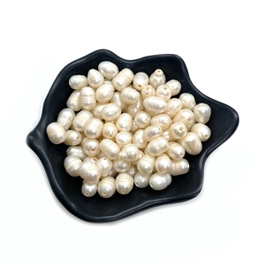 Perle naturali d'acqua dolce per collane fai-da-te su un piatto di ceramica nero