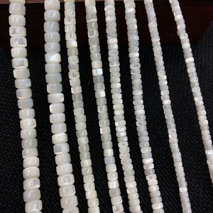 Macro shot of white mother of pearl square beads showing natural luster and smooth texture