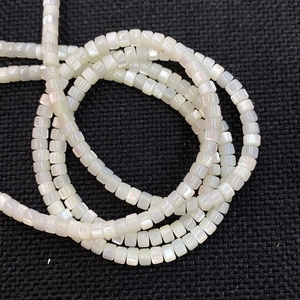 Macro shot of natural white shell cylinder beads with iridescent luster for DIY jewelry
