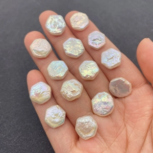 Handheld weergave van 12 mm natuurlijke witte hexagonale zoetwaterparels met regenboogglans