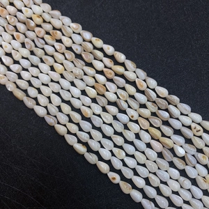 Natürliche Muschel-Tropfenperlen 5x8mm für DIY-Schmuckherstellung auf dunklem Stoff