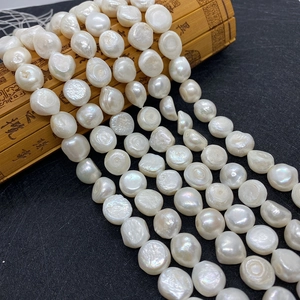 Nahaufnahme weißer Barockperlen 9-12mm auf einer traditionellen Bambusrolle