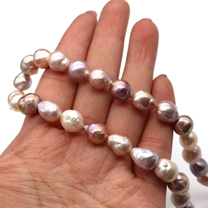 Macro detail of 10-11mm natural Edison baroque pearls in hand showing rich luster
