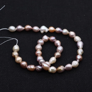 Macro shot of natural multi-color baroque Edison pearls in white, pink, and purple shades