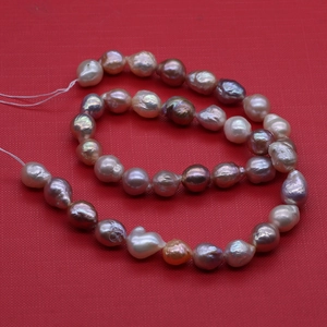 Macro detail of multi-color baroque Edison pearls in white, pink, and purple hues