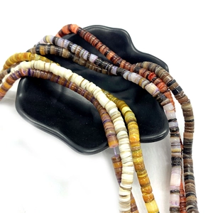 Natural dyed heishi shell beads 5-8mm in mixed earthy colors displayed on a black ceramic tray