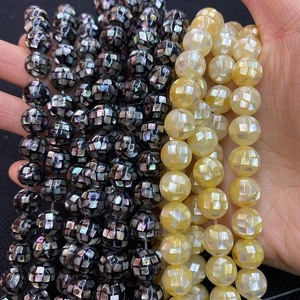 Detailed view of mosaic mother of pearl shell beads in iridescent dark grey and yellow