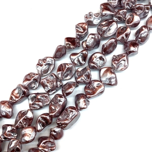 Macro detail of irregular baroque shell beads with bronze metallic luster for DIY jewelry