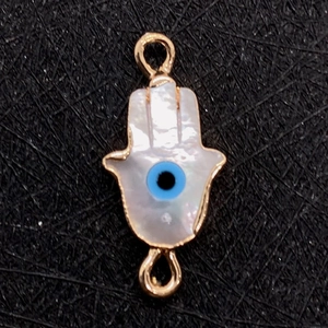 Dettaglio del ciondolo mano di Hamsa in conchiglia con occhio e placcatura oro