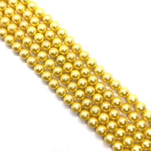 Macro view of rows of glossy golden faux pearls for DIY jewelry making and accessories
