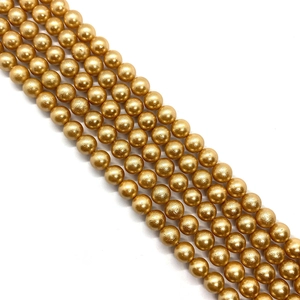 Macro shot of gold pearl beads with metallic finish for DIY jewelry crafting