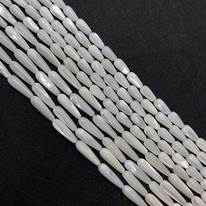 Polished white mother of pearl teardrop beads for DIY jewelry making on dark background