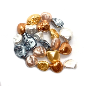 Vista macro di perle barocche strutturate metalliche per gioielli fai-da-te in oro e argento
