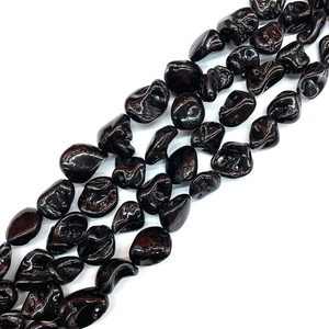 Macro shot of irregular polished black shell beads with high gloss finish for DIY jewelry