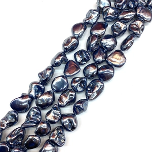 Macro detail of irregular deep blue baroque shell beads with iridescent rainbow luster