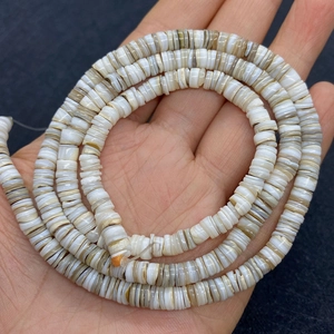 Nahaufnahme von natürlichen Muschel-Heishi-Perlen in neutralen Farben für DIY-Schmuck