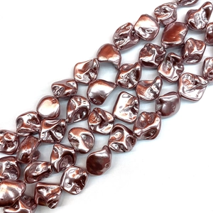 Detailed view of rose gold baroque shell beads for DIY jewelry with metallic texture