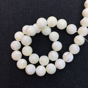 Makro-Detail von runden weißen Muschelperlen mit irisierendem Glanz für Schmuckdesign