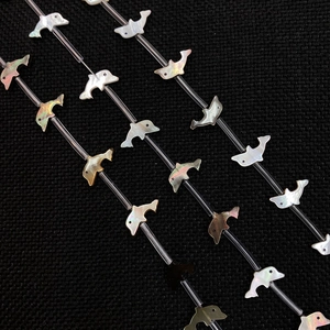 Macro view of dolphin shaped natural mother of pearl loose beads for DIY jewelry making