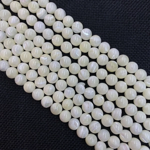 Nahaufnahme von 8-12mm runden Muschelperlen mit irisierendem Glanz auf schwarzem Grund