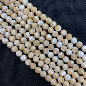 Detail von natürlichen runden Muschelperlen mit cremeweißen Wirbeln und warmem Glanz