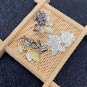 Macro-opname van handgesneden goudviskralen van natuurlijk parelmoer voor DIY-sieraden