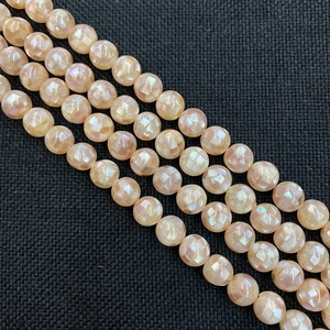 Vue détaillée de perles rondes en nacre naturelle facettée avec texture mosaïque