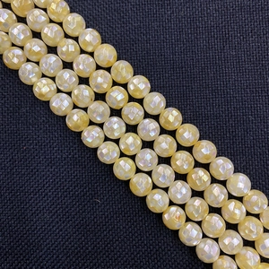 Vue détaillée de perles en coquillage facettées aux reflets dorés pour bijoux DIY