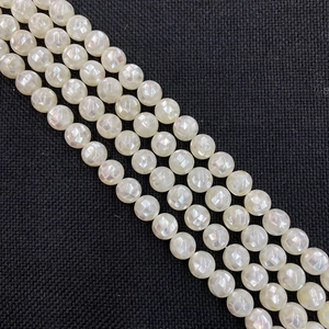 Macro de perles de nacre facettées irisées de 8 mm avec un éclat nacré sur tissu noir