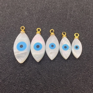 Five pieces of marquise natural shell evil eye pendants with gold loops in varying sizes