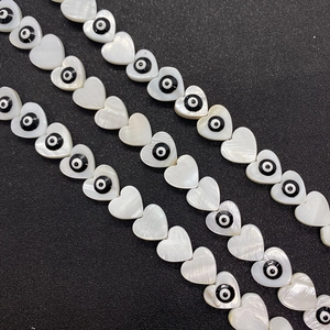 Macro shot of heart-shaped shell beads with evil eye motif for DIY jewelry making