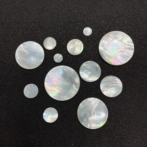 Macro shot of natural white mother of pearl shell beads with iridescent luster on dark background