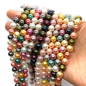 Perle di vetro tonde colorate da 8-10mm tenute in mano per la creazione di gioielli fai-da-te