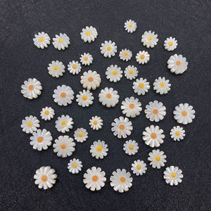 Dettaglio di perline a forma di girasole in conchiglia bianca per creazione gioielli fai da te