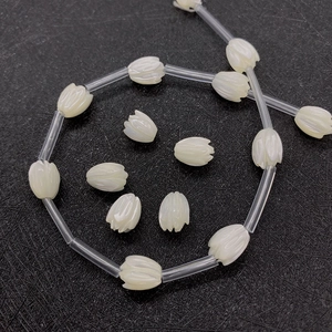 Macro detail of tulip-shaped white sea shell beads with polished natural pearl luster