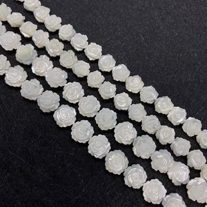 Perles de rose en nacre blanche de 8mm pour bijoux DIY sur un fond noir à texture mate