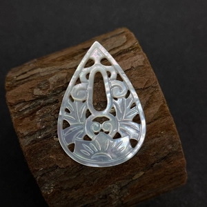 Detailed view of hollow water drop white mother-of-pearl shell pendant with carvings