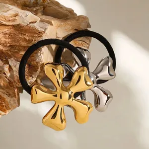 Golden and silver flower hair ties with metallic finish on natural stone background
