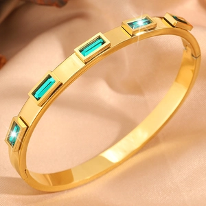Dettaglio del bracciale rigido placcato oro 18K con cinque pietre preziose verde smeraldo
