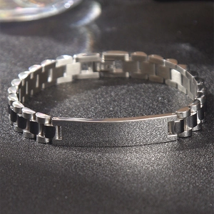 Vista macro de pulsera tipo reloj de acero con placa ID mate y eslabones pulidos brillantes