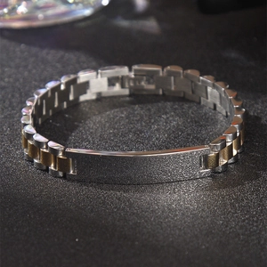 Detalle macro de pulsera bicolor de acero inoxidable con placa de metal esmerilado
