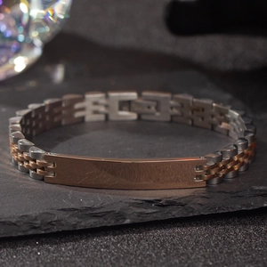 Detail of two-tone stainless steel link bracelet with custom engravable nameplate plate