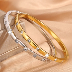 Polished gold and silver titanium steel bangles with sparkling zircon inlay on satin