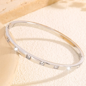 Macro view of silver titanium steel bracelet featuring round zircon inlay and side clasp