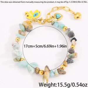 Makroaufnahme Naturstein-Perlenarmband mit goldenem Elefant und Türkis-Herzanhänger