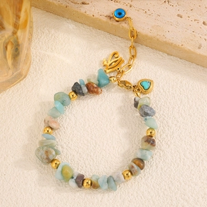 Detail eines Boho-Armbands aus Naturstein mit blauem Auge und Herz-Anhängern