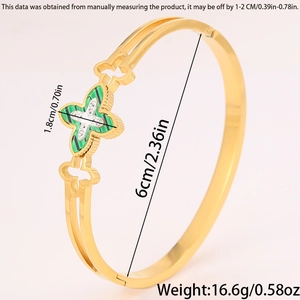Detailed macro of gold clover bracelet with green inlay and sparkling crystal settings
